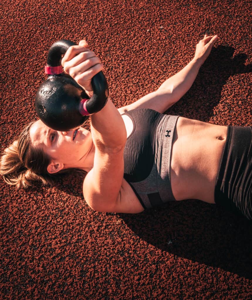 Active woman lifting kettlebell during workout.