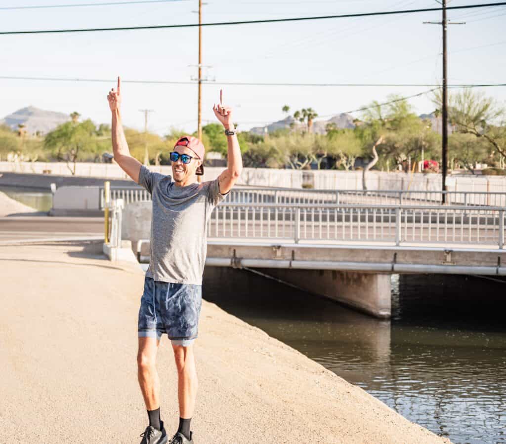 Vibrant runner celebrating success outdoors during a training session on a sunny day.