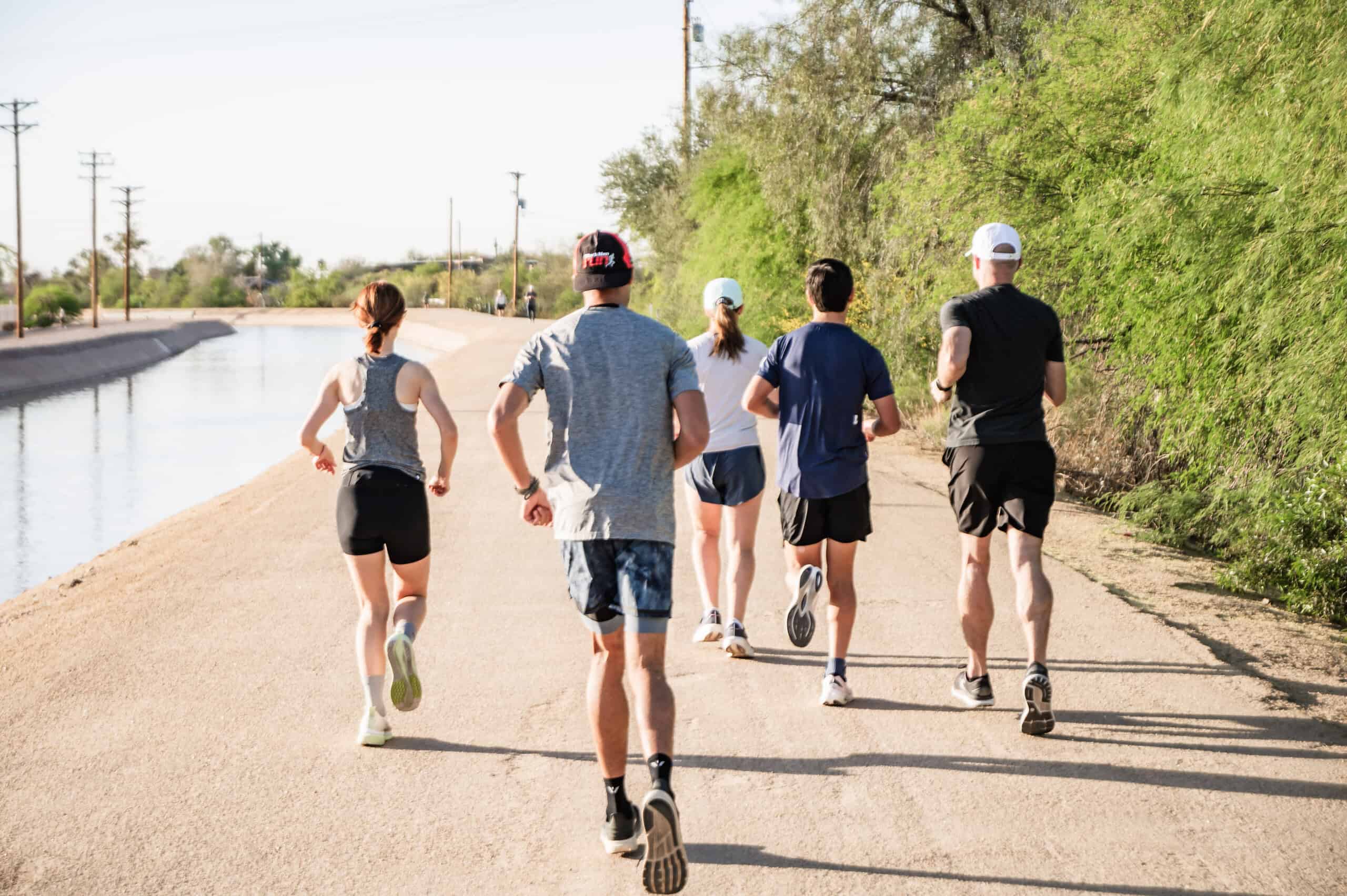 Alt text: Group of runners on a scenic trail during a running coaching session for triathletes.
