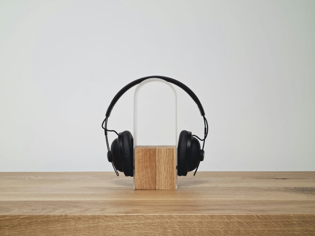 Black headphones on modern wooden stand